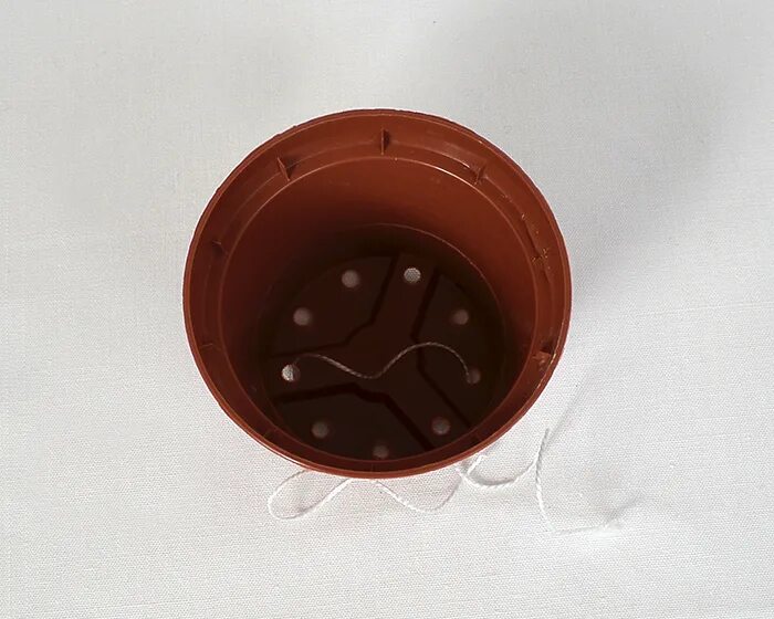 горшок с отверстиями. отверстия в горшке для цветов. отверстия в цветочных горшках. растение в горшке. отверстия в цветочных горшках.