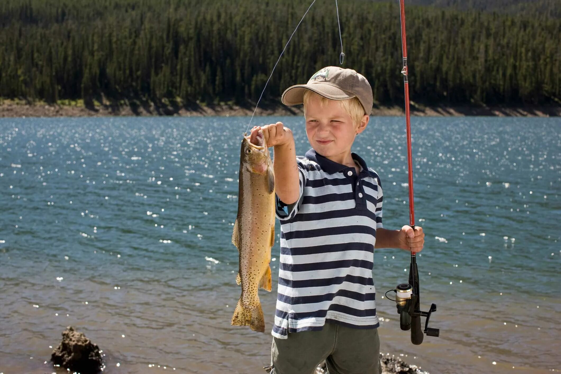 Рыбу удят удочкой. Дети на рыбалке. Поймал рыбу. Мальчик с рыбой. Детишки на рыбалке.