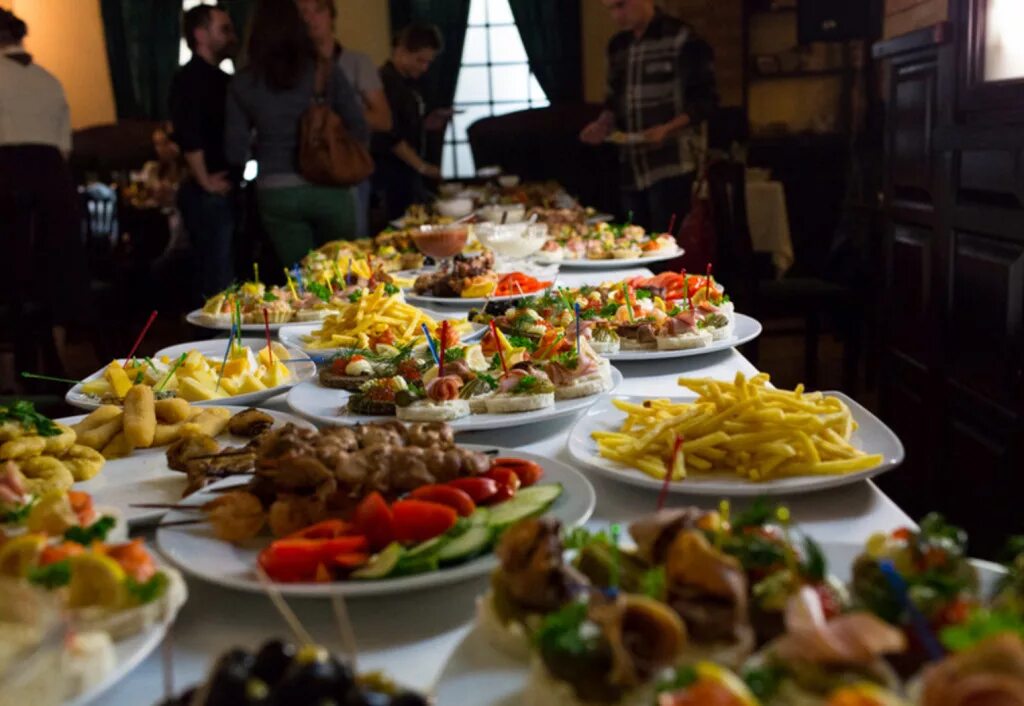 Богато накрытый стол. Современный праздничный стол. Огромный стол с едой. Заставленный стол. Заставленный стол.