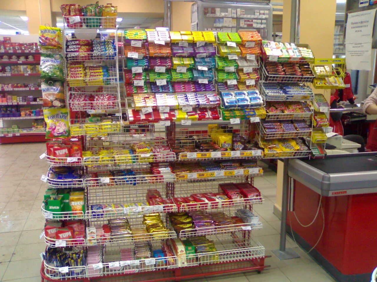 Прикассовая зона продуктового магазина. Оборудование для прикассовой зоны. Выкладка прикассовой зоны. Кассовый бокс для магазина. Ассортимент прикассовой зоны.