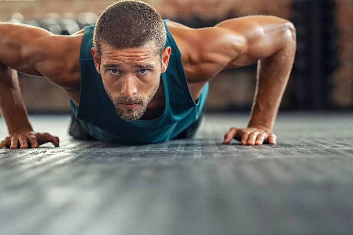 Спортсмен в зале. Физическая форма. Программа упражнений в тренажерном зале для мужчин 3. Спортивные упражнения. Человек отжимается.
