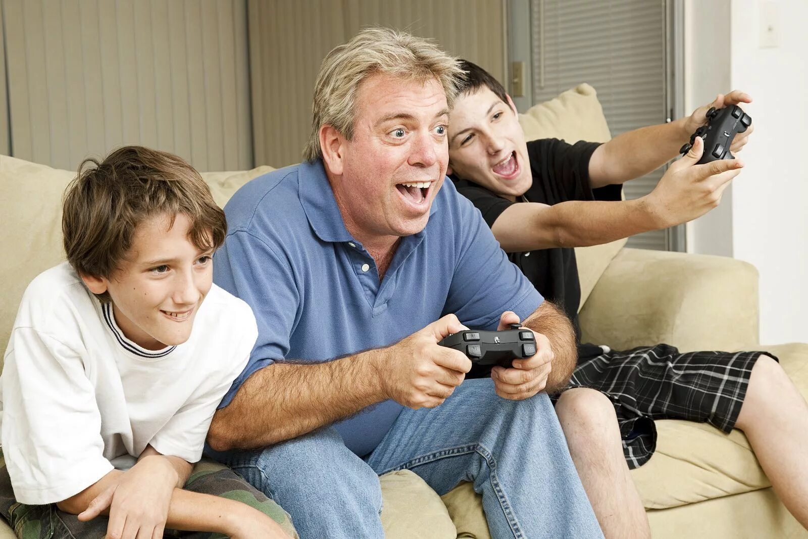 Родители играют с детьми в компьютерные игры. Папа и сын играют в приставку. Отец и сын подросток. Сын дяди.