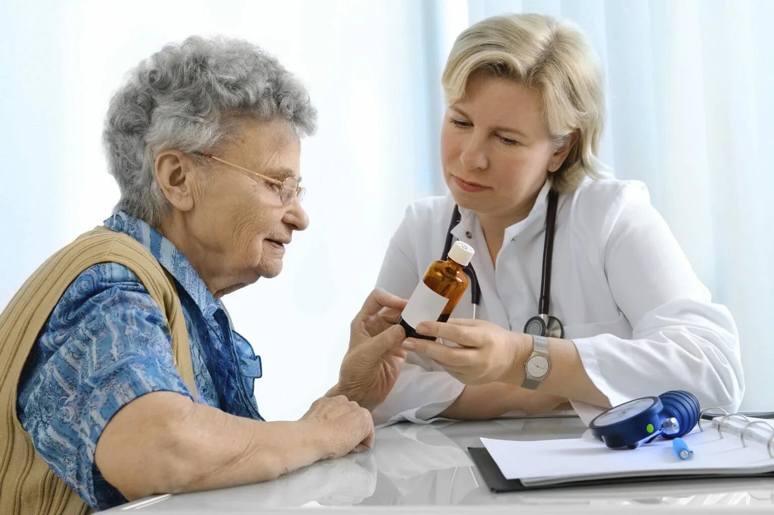 Пожилой врач. Пожилой человек у врача. Бабушка у врача. Беседа врача с пациентом.