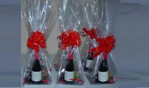 Шампанское и конфеты в упаковке. Ваза с конфетами в подарок. Как упаковать шампанское в прозрачную пленку. Упаковка подарка в прозрачную пленку. Как упаковать шампанское в прозрачную пленку.