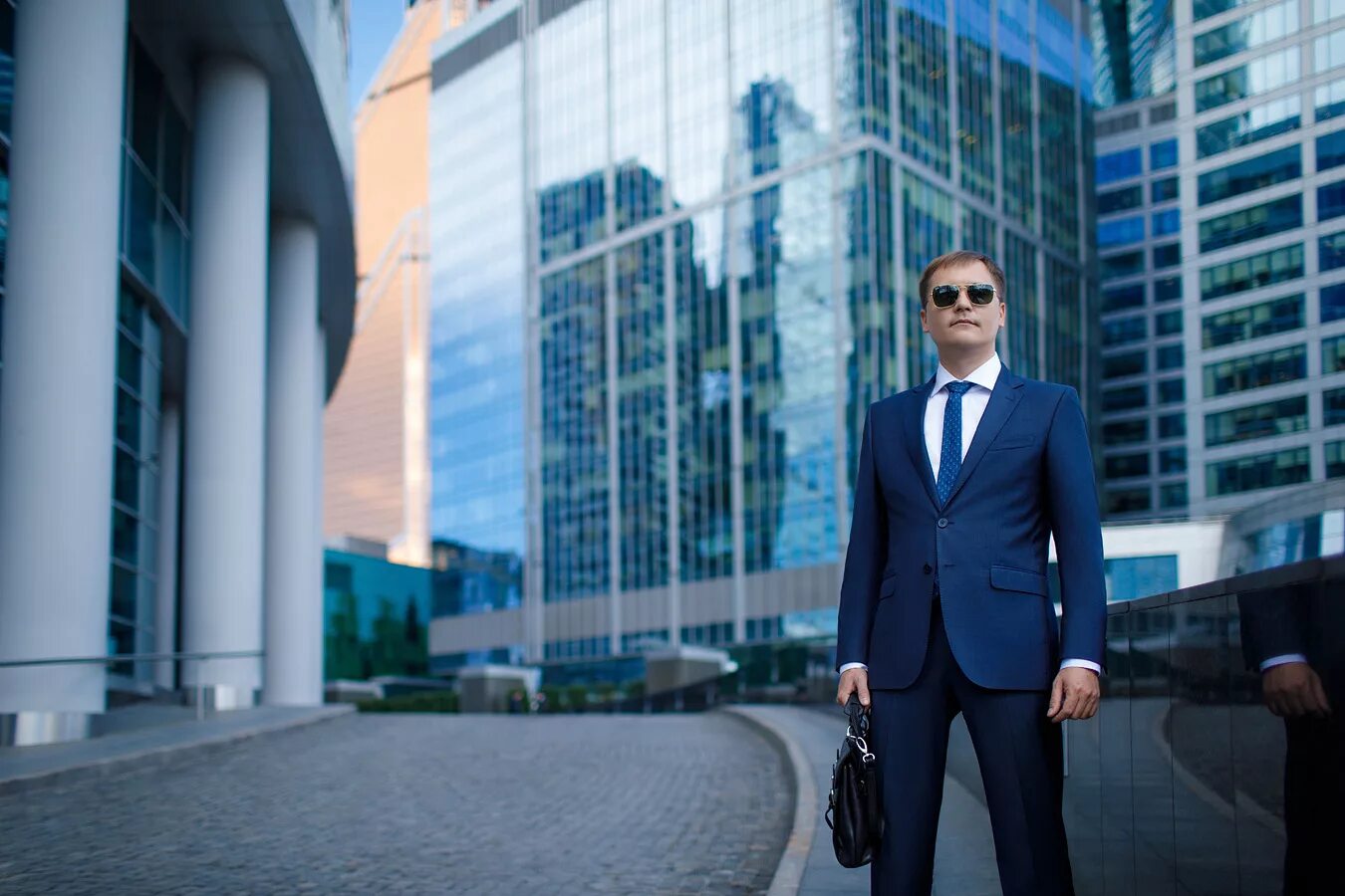 Бизнесмен на фоне города. Солидный город. Солидный город. Успешный мужчина. Элегантный костюм мужской.