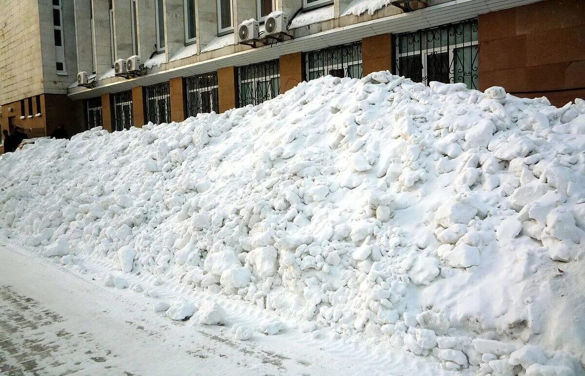 Много снега. Сугробы в городе. Гора снега во дворе. Огромная куча снега.