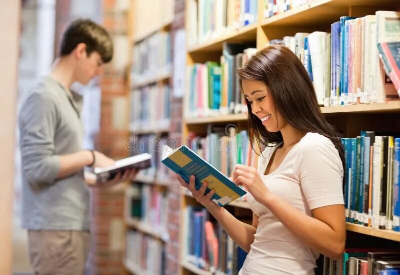 Девушка держит книгу. Студенческие чтения. Мужчина и женщина в библиотеке. Студент держит книжки. Книги читать архив