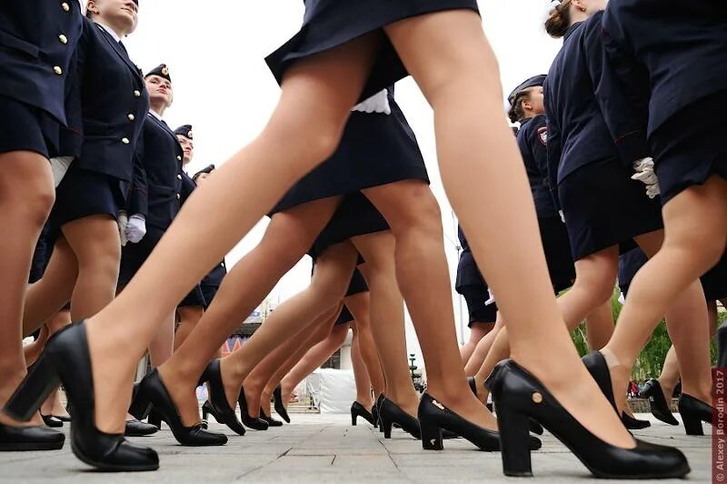 Снизу ходят. Женские ноги на параде. Женщины в юбках на параде. Под юбкой на параде. Маршируют в коротких юбках.