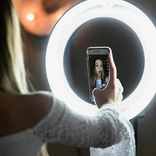 woman using camera in ring light.