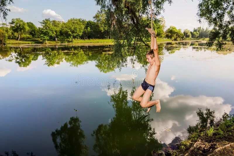 В воде ныряет в реку. Прыгает в речку. Прыжок с тарзанки в реку. Прыжок в озеро. Прыгает в реку.