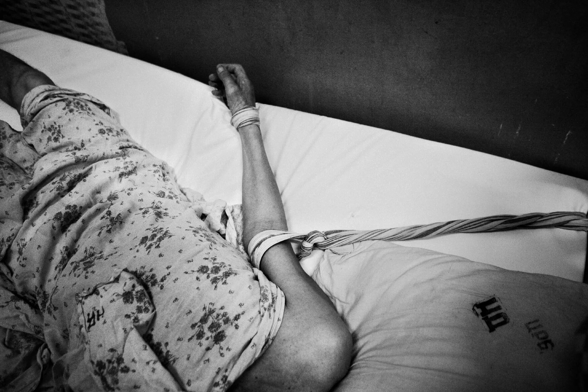 Привязанный человек к кровати. Человек прикованный к постели. Прикованный к постели больной.