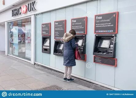 Customer Standing at ATM Cash Machines in Side of HSBC Bank Branch. 
