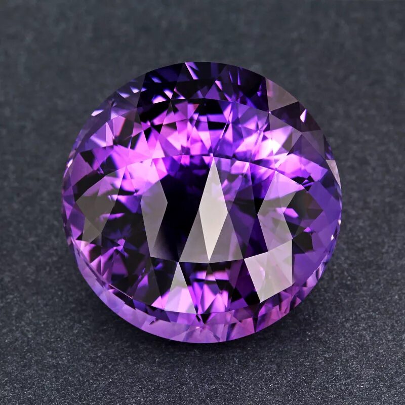 россыпь драгоценных камней. сиреневый аметист. лиловый аметист корунд. фиалковый аметист камень. полудрагоценный камень аметист.