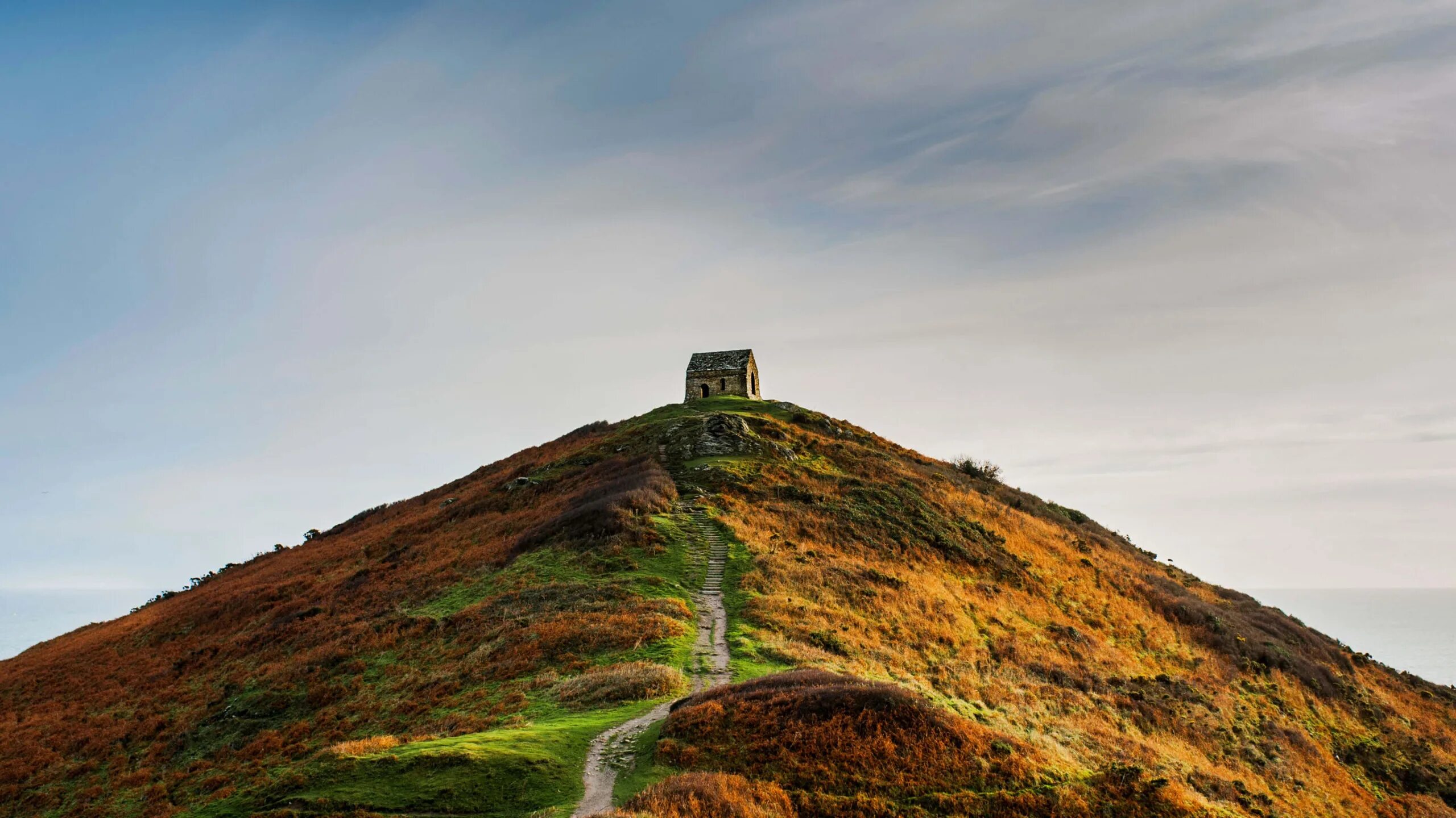Вершину холма украшает бронзовая. Англия домик горы. Вершина холма. Корнуолл осень. Зелёные холмы руины.