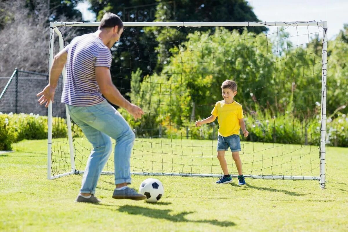 Отец и сын футбол. Папа играет в футбол. Папа и сын футбол на газоне. Папа с сыном играют в футбол. Папы играют в футбол