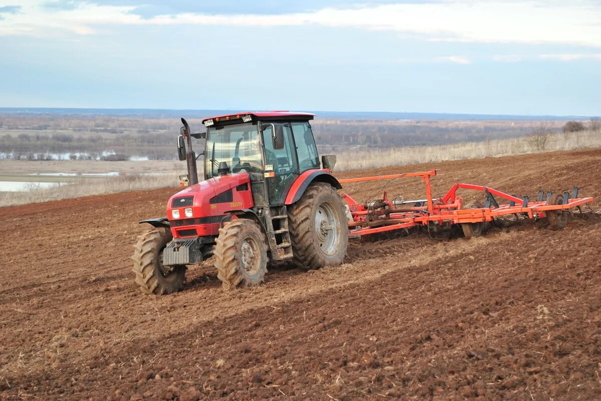весенние полевые работы. трактор мтз 1222 с сеялкой. техника полевых работ. тракторист сельское хозяйство. мтз 1523 с дискатором.