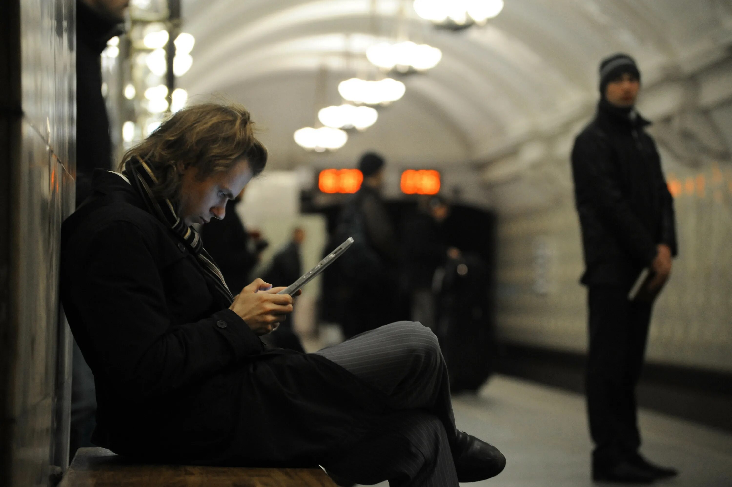 Люди с телефонами в метро. Телефон в метро. Люди со смартфонами в метро. Человек сидит в метро. Она читает в метро