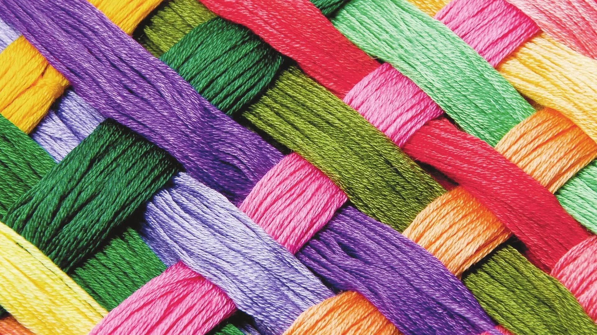 Синтетические нитки. Цветные нитки. Клубок разноцветных ниток. Вязаное полотно. Нитки фон.