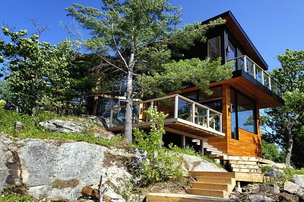 Дом хвойное купить. Онтарио Канада коттеджи у озера. Деревянные дома на склоне. Деревянный дом на склоне. Дом в лесу на склоне.