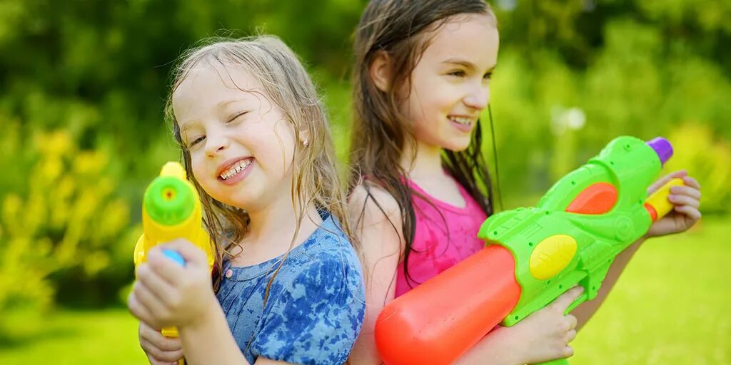 While children play. Счастливые дети играют с аниматорами. играет с погремушкой. малыш играет с погремушкой. гамбургер без сыраstock-photo-child-playing-with-water-gun-toy-lying-at-park-grass-in-a-sunny-day-489289288.