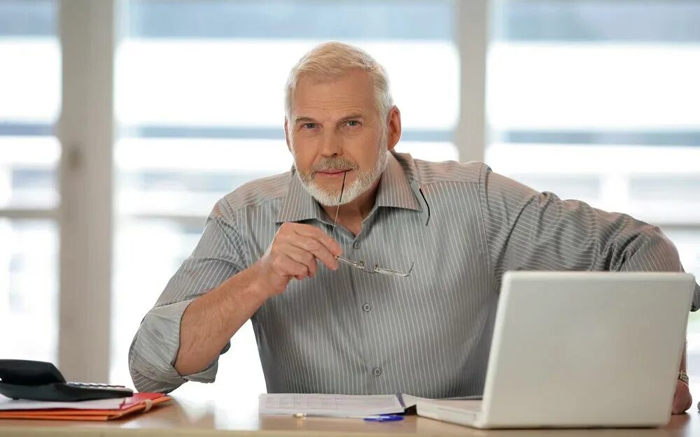 Бизнесмен 50 лет. Взрослый человек за компьютером. Бизнесмен 50 лет. Седой мужчина в офисе. Мужчина в зрелом возрасте.