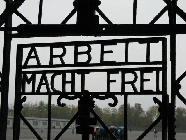 Что написано на воротах освенцима. Ворота концлагеря дахау. ворота концлагеря с надписью. надписи на концлагерях. лагерь дахау надпись на воротах.