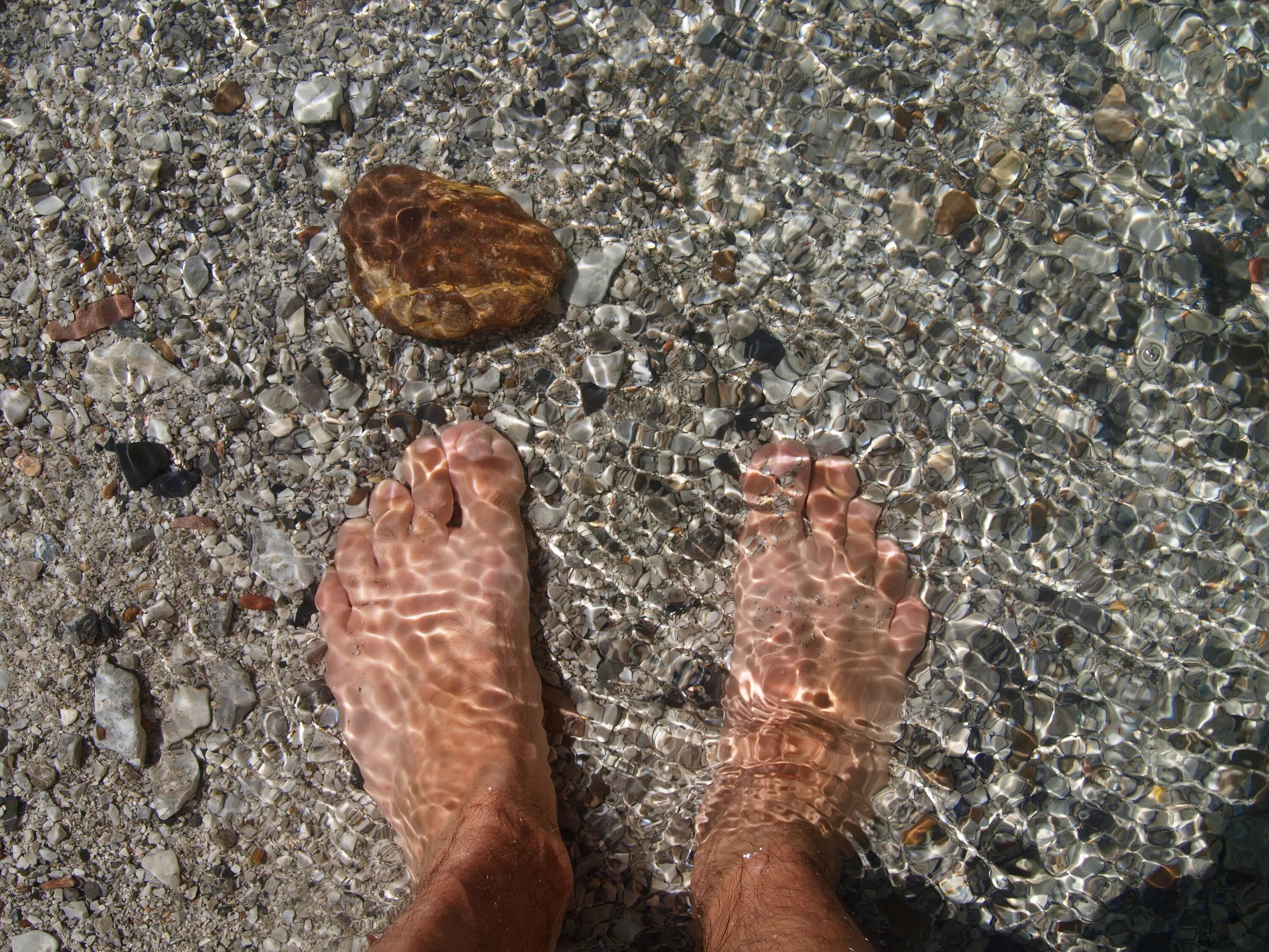 Мужские ноги в воде. Каменные ноги. Ноги в морской воде. Ноги в прозрачной воде. Течет вода из ноги