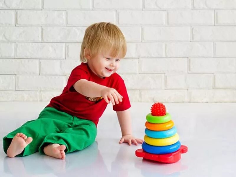 Мальчик играет на полу. Игрушки для детей. Пирамидка для детей. Пирамидка и игрушки для мальчика. Ребенок с игрушкой на полу.