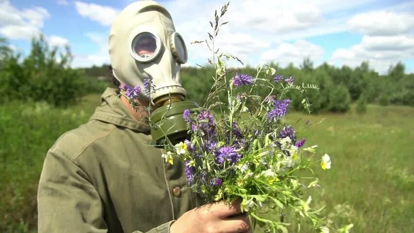 Защищает ли. Нюхать цветы в противогазе. Человек в противогазе нюхает цветок. Нюхают цветы через противогаз. Спасем природу человек в противогазе.