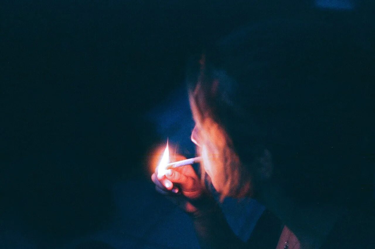 Сигарета мелькнула во тьме. Сигарета в темноте. Курит в темноте. Человек с зажигалкой в темноте. Парень с сигаретой в темноте.
