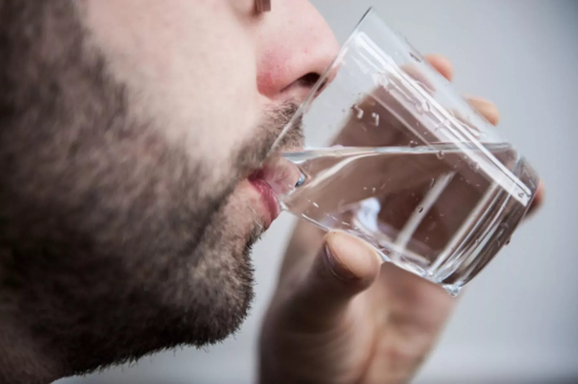 Мужчина пьет воду. Парень пьет воду. Глоток воды. Мужчина пьет воду из стакана. Жадно пьет воду