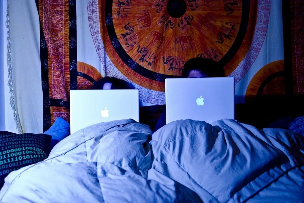 Человек на кровати с ноутбуком. Ноутбук на кровати. Ноутбук в постели. Комната с ноутбуком на кровати.