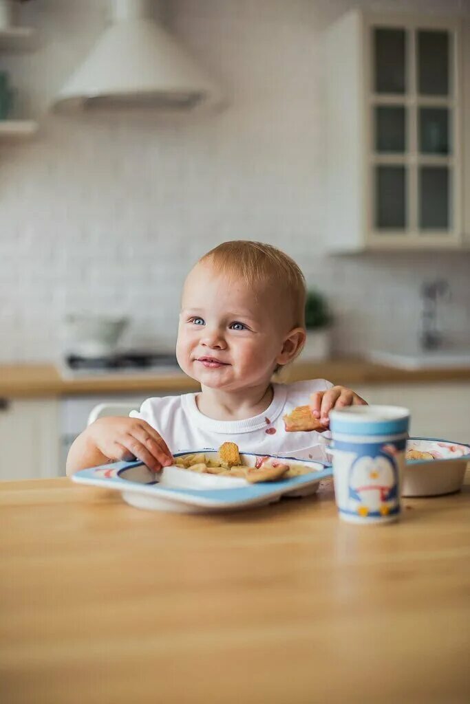 Кушаем кашку. Дети за столом. Ребенок завтракает. Маленький ребенок ест. Малыш за столом.