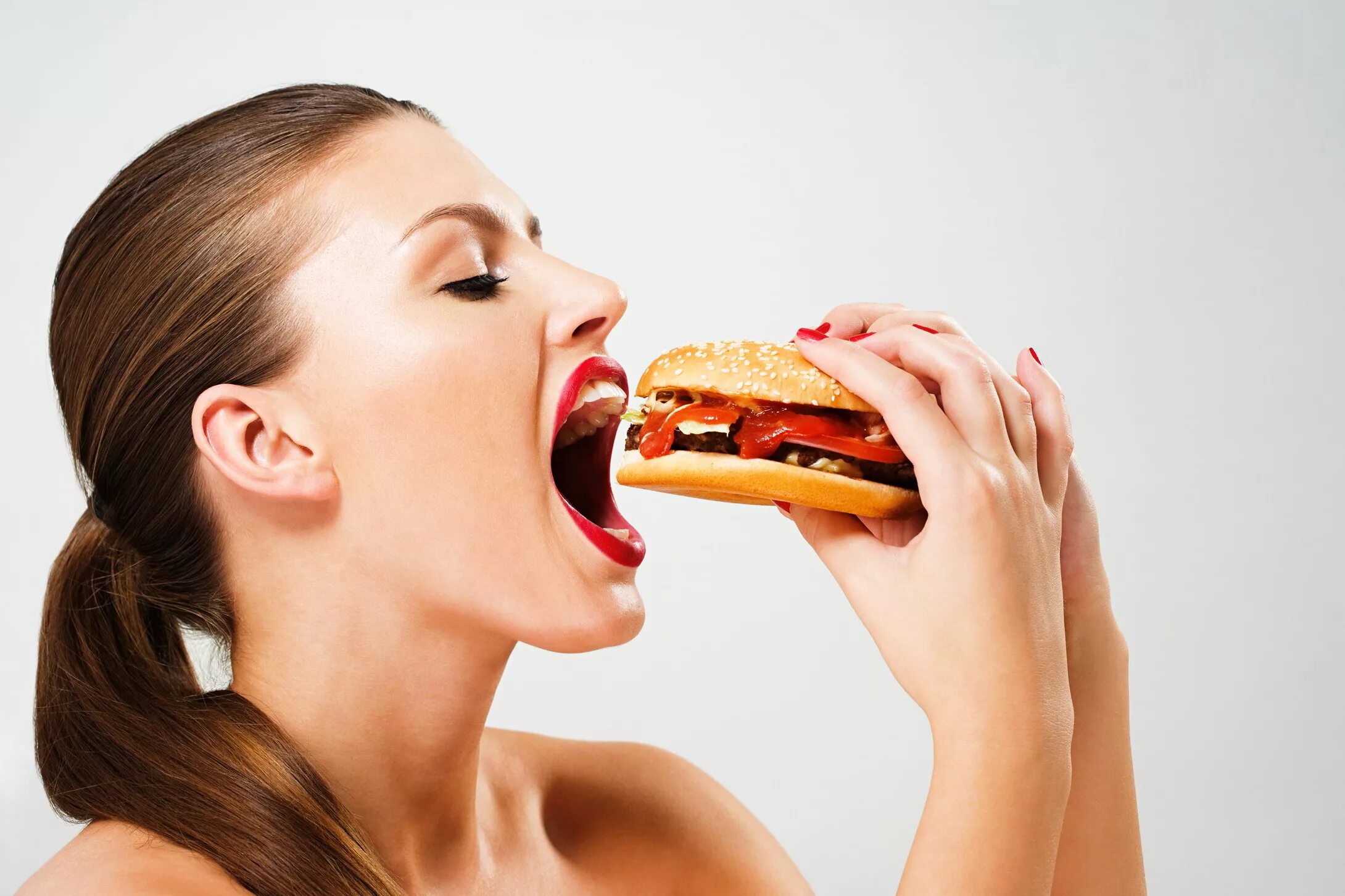 Девушка ест гамбургер. Человек с едой. Девушка с бутербродом.