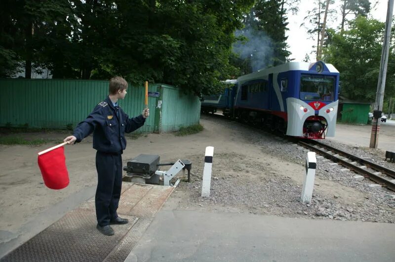 Шлагбаум перед поездом. Железнодорожный переезд. Регулировщик поездов на железной дороге. Дежурный по железнодорожному переезду. Пропустить переехать