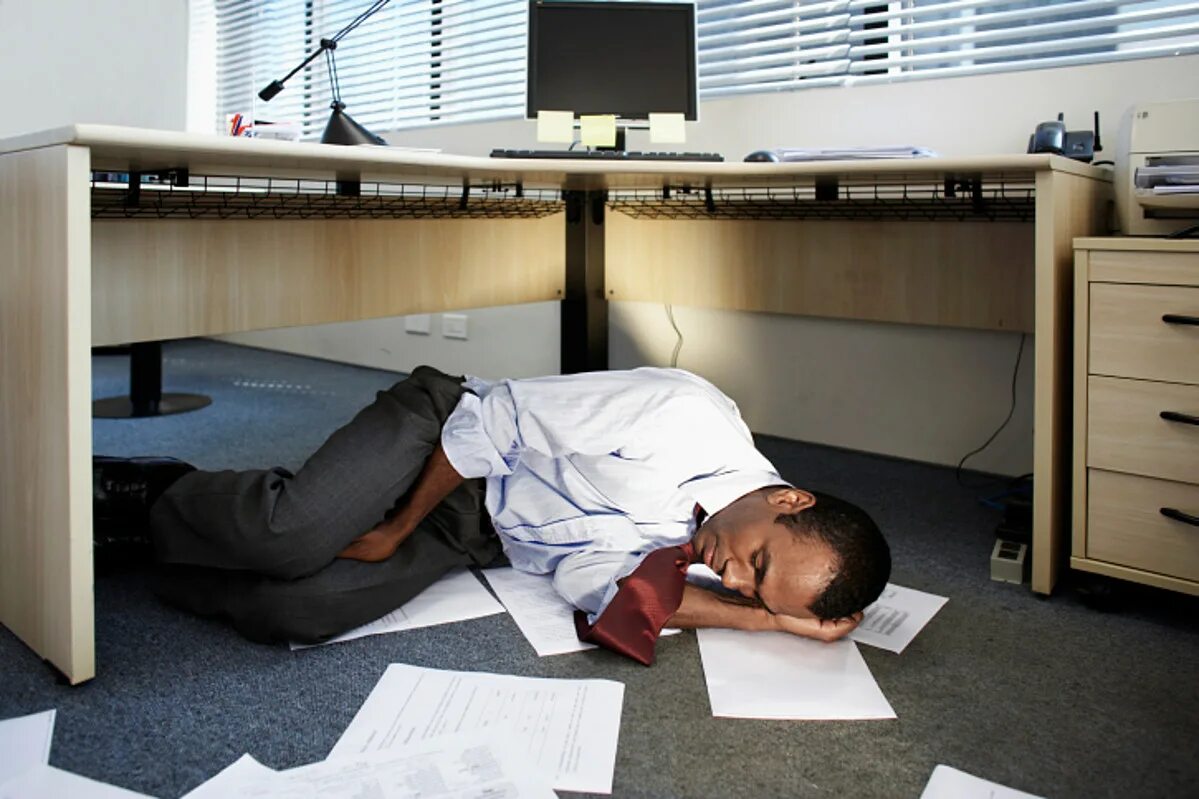 He was exhausted. Спит на работе. Уставший человек в офисе. Человек под столом. Спит в офисе.