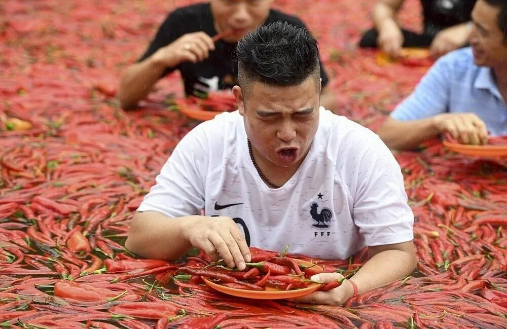 Соревнования по поеданию перца. Соревнования по поеданию острого перца. Китайские люди.