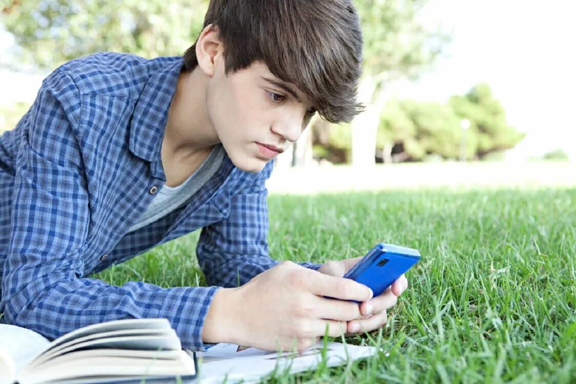 Boy s books. Подросток со смартфоном. Подросток с телефоном. Юноша со смартфоном. Подросток сидит в телефоне.