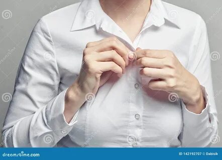 Photo about Business woman in white blouse unbuttoning her shirt, close up....