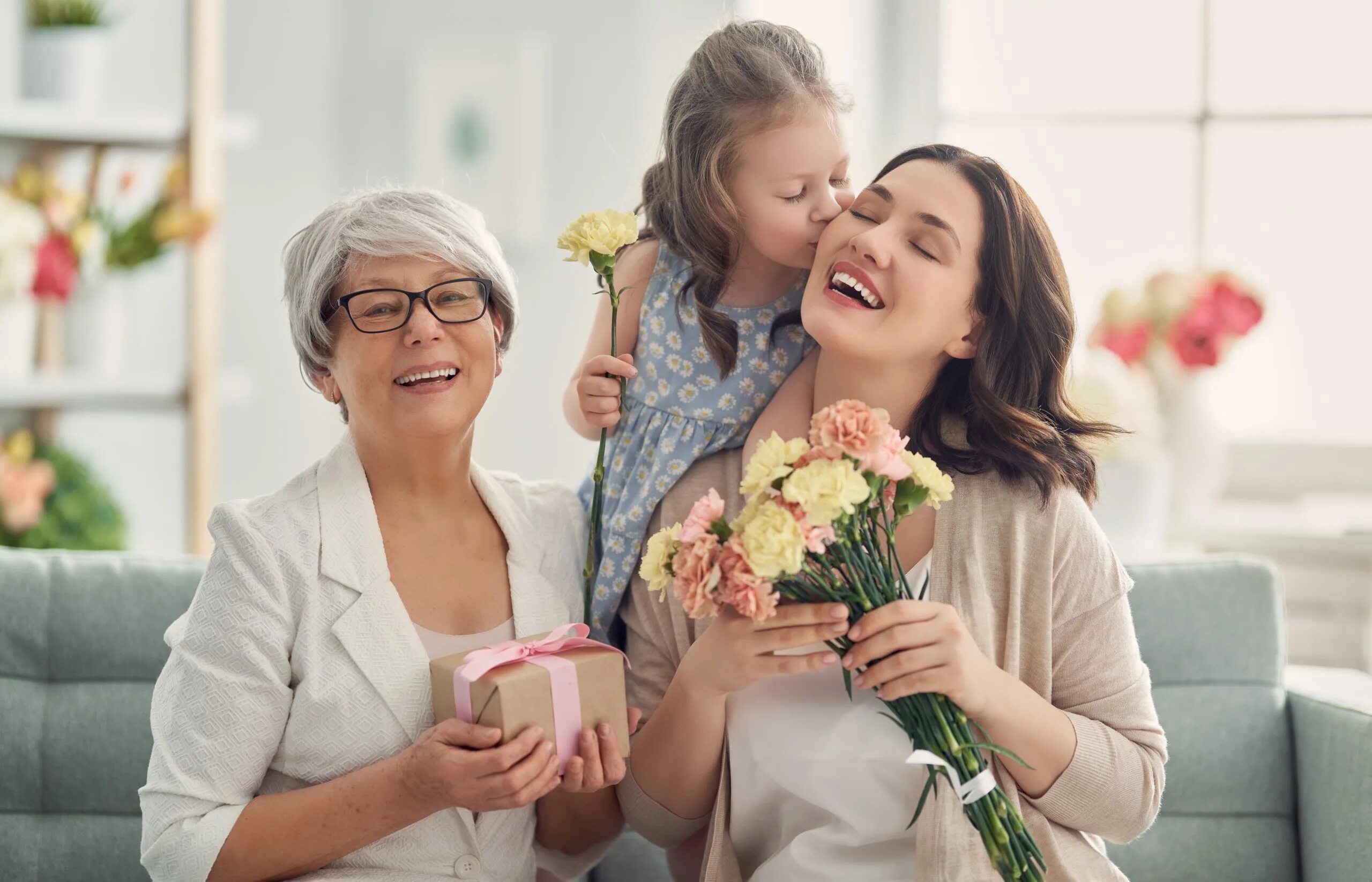 Mums daughters. Бабушке дарят цветы. Give Flowers to mum. Kid grandma Gift Happy. Family is hugging in the House.