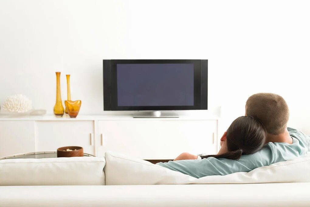 В спальне перед телевизором. Человек перед телевизором. Пара на диване перед телевизором. Диванчик перед телевизором. Семья на диване перед телевизором.