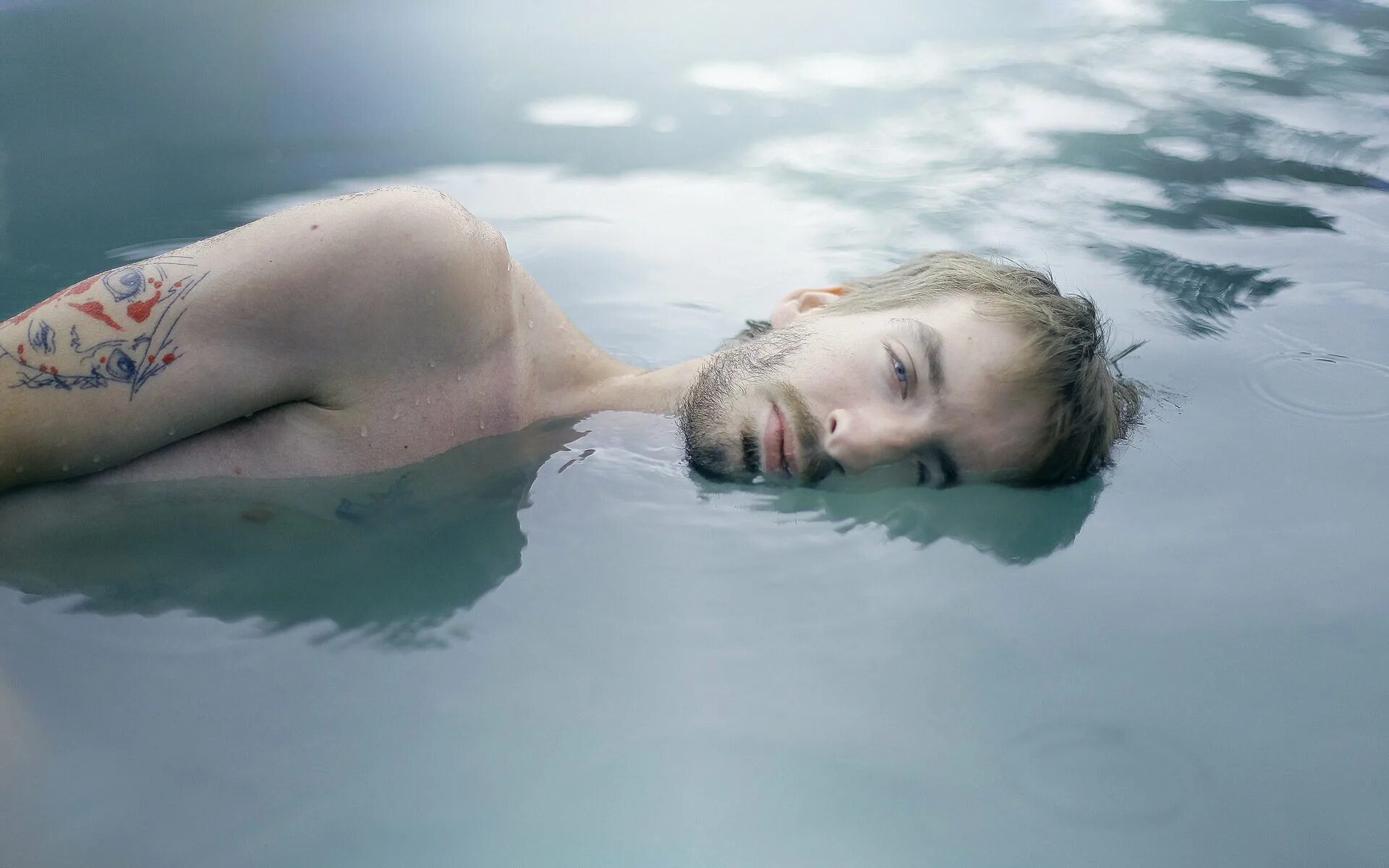 Лежать на воде. Парень в воде. Парень лежит в воде. Фотосессия в воде.