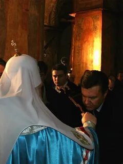 Целует руку священнику