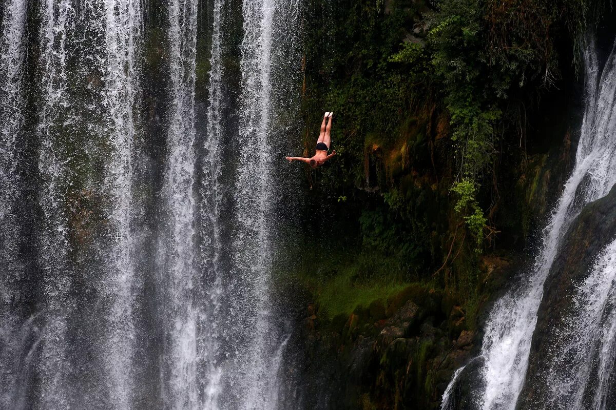 Человек под водопадом. Прыжок с водопада. Купание в водопаде. Прыгают с водопада.