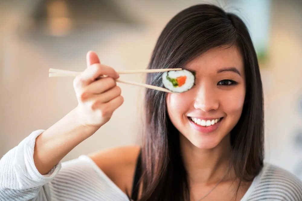 Японка с роллами. Японцы едят суши. Девушка ест роллы. Люди едят роллы. Девушка есть суши