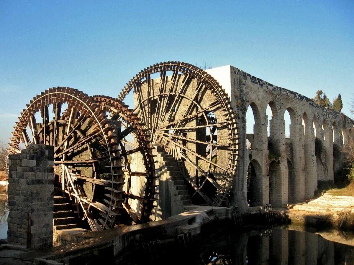 Situated on the banks. Нории в Сирии Хама. Водоподъемное колесо в древнем Египте. Водоподъемные колеса Сирия. Древние водяные колеса-нории в Сирии.