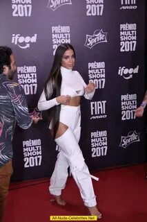 Singer Anitta sexy in white outfit at red carpet.