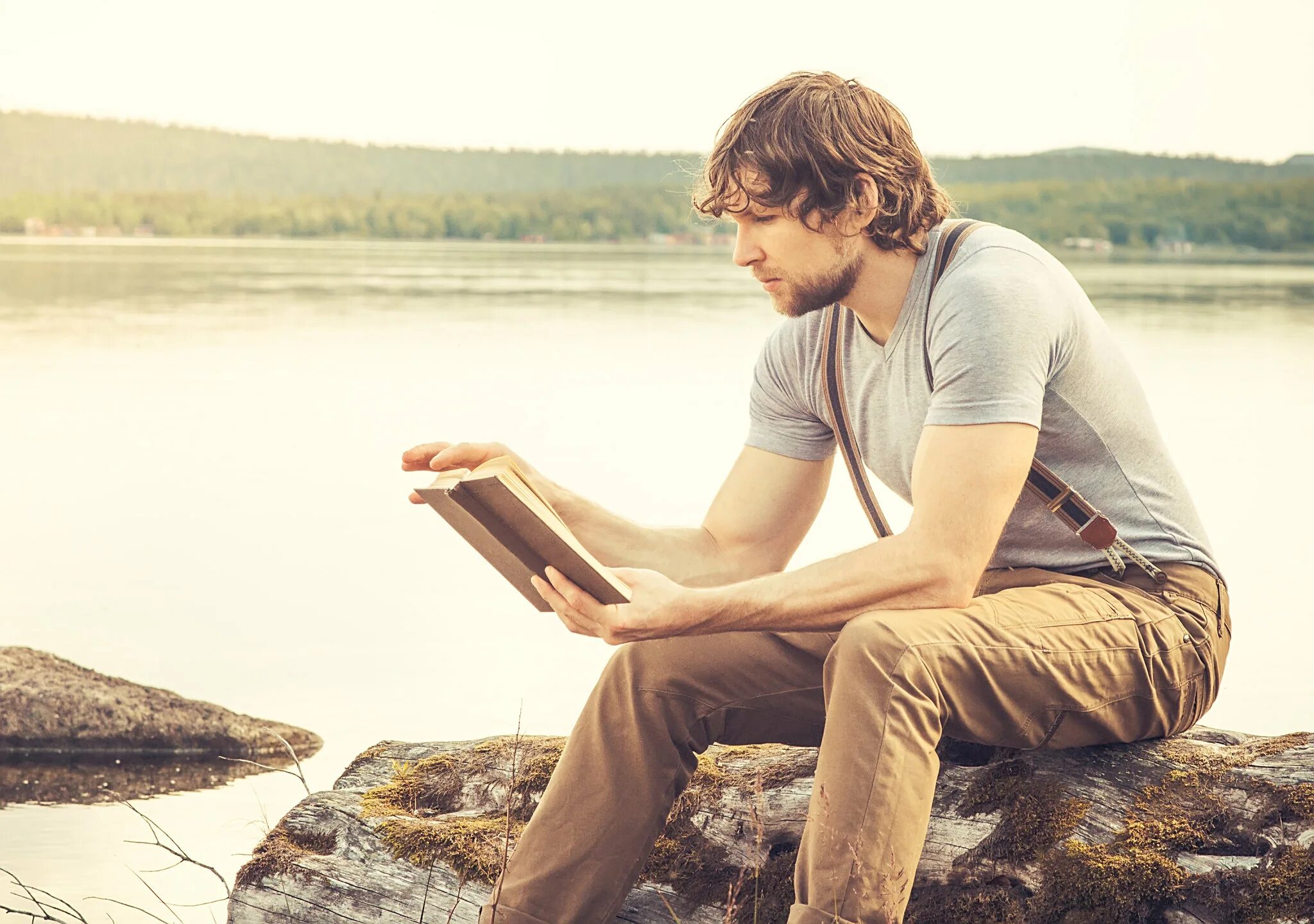 Reading books is useful. Мужчина с книгой возле воды. a man standing reading a book.
