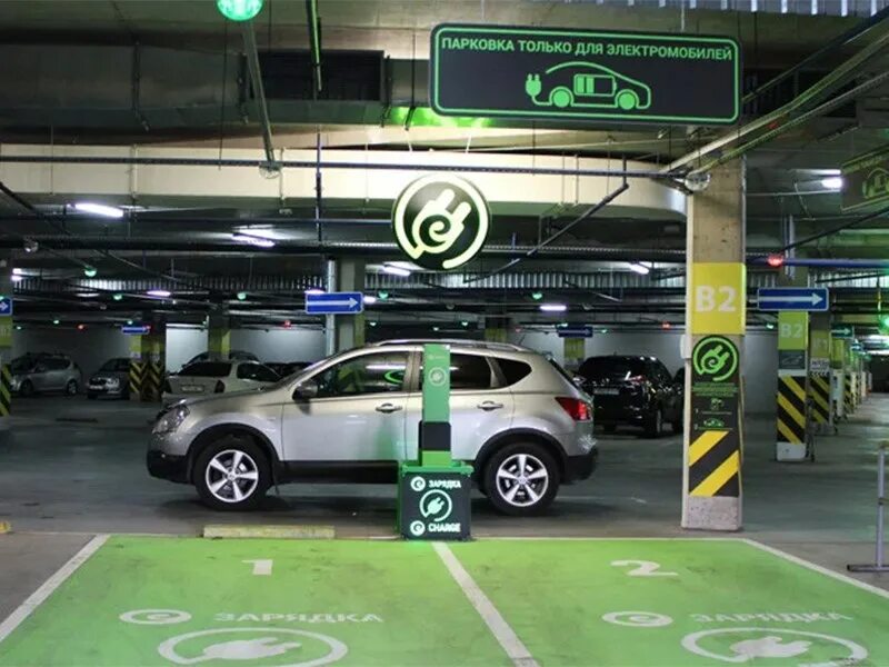 зарядка для электромобилей в паркинге. зарядная станция в паркинге для электромобиля. зарядка для электрокара в паркинге. зарядная станция для электромобиля тесла. зарядные станции для электромобилей в подземном паркинге.