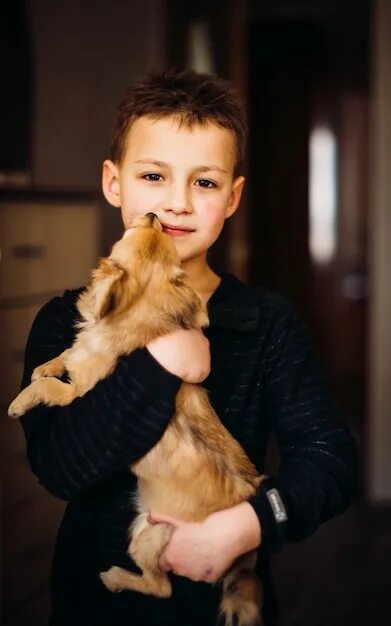 Мальчик держит собаку. Мальчик с собакой на руках. Мальчик держит щенка на руках. Парень держит щенка на руках.